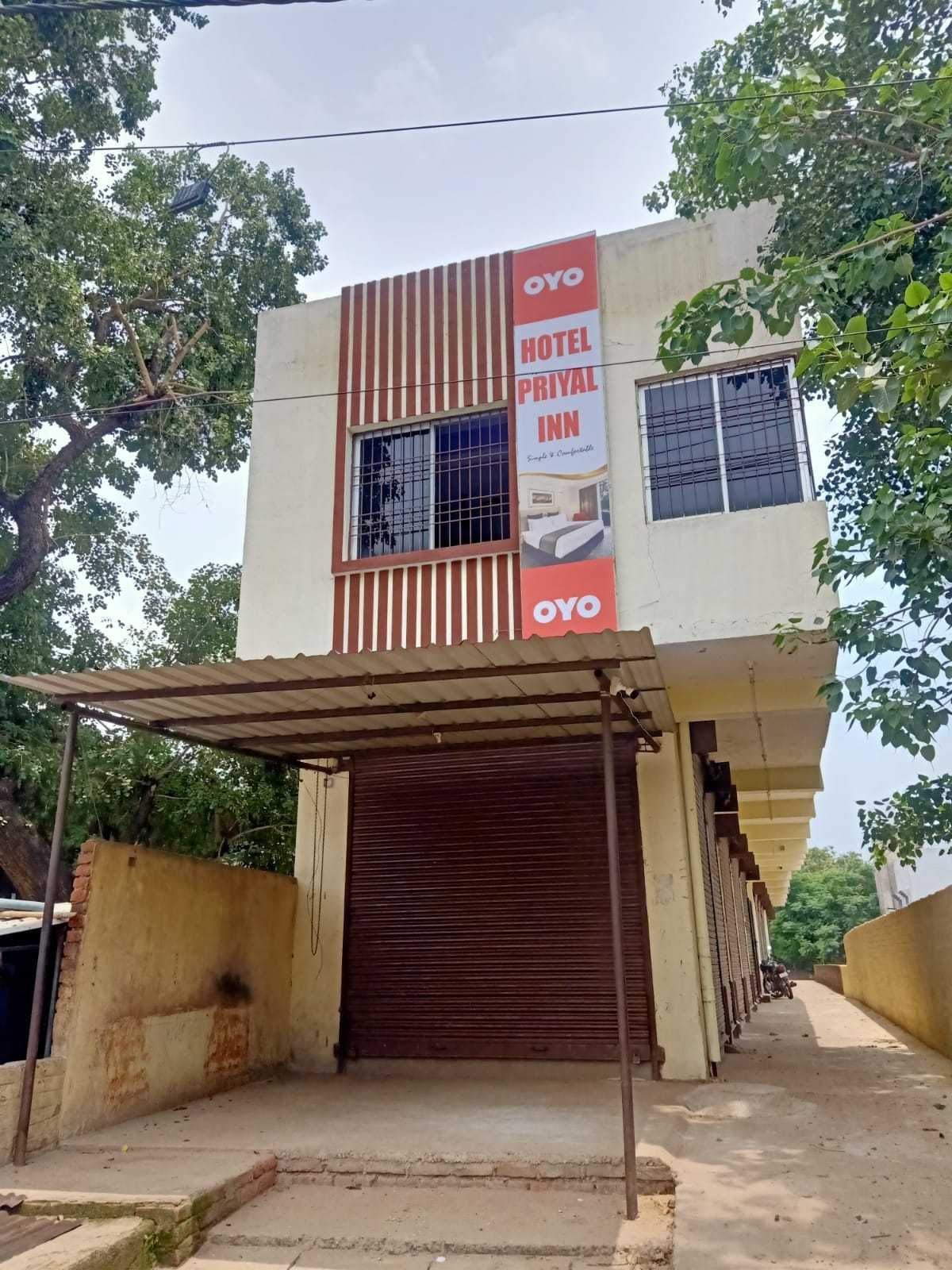 A building with a sign for 'OYO HOTEL PRIYAL INN' and a covered entrance.
