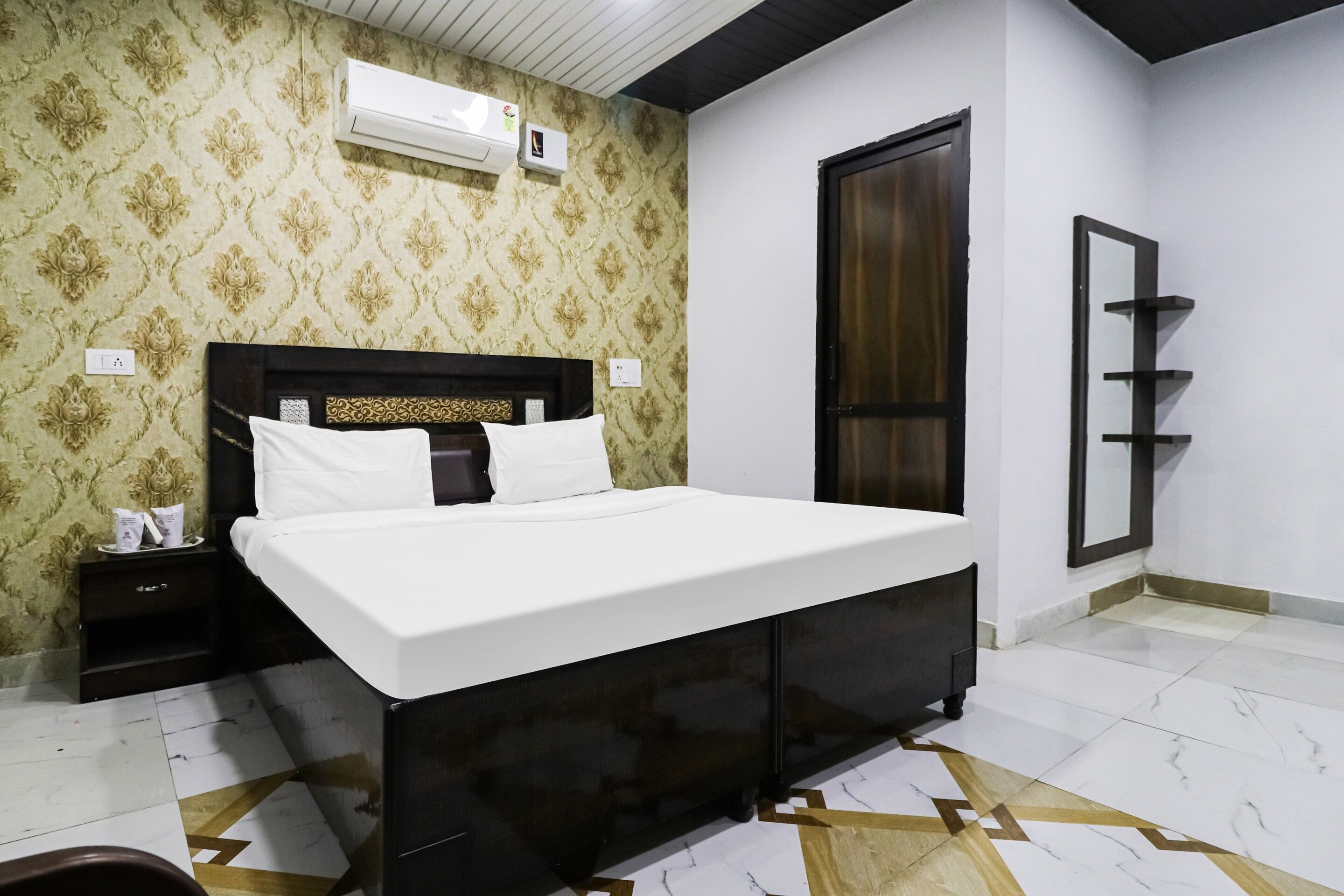 Une chambre à coucher comprenant un lit, une table de chevet, une armoire et un appareil de climatisation.