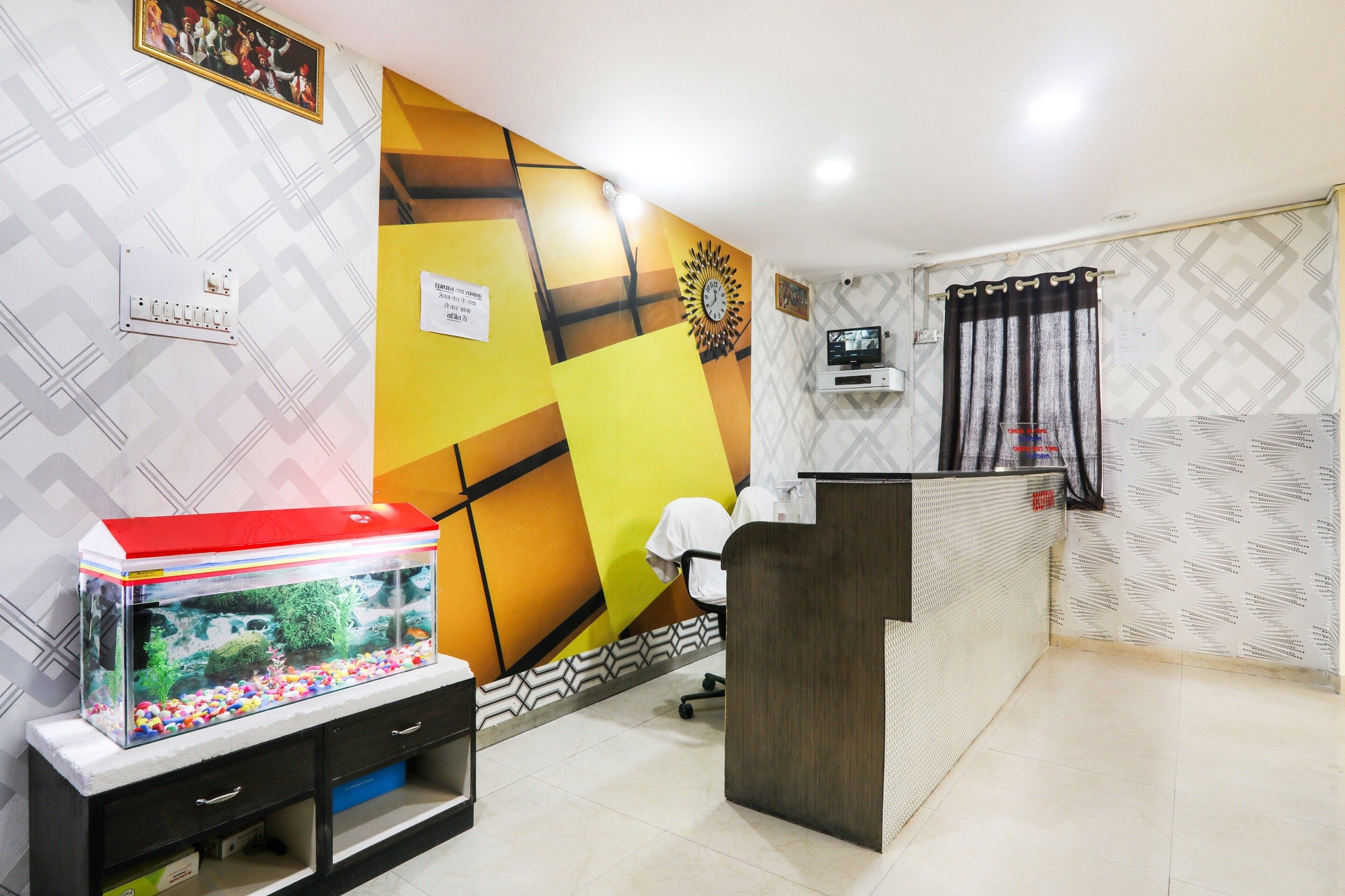 A reception area with a fish tank, a clock, and a television on the wall.