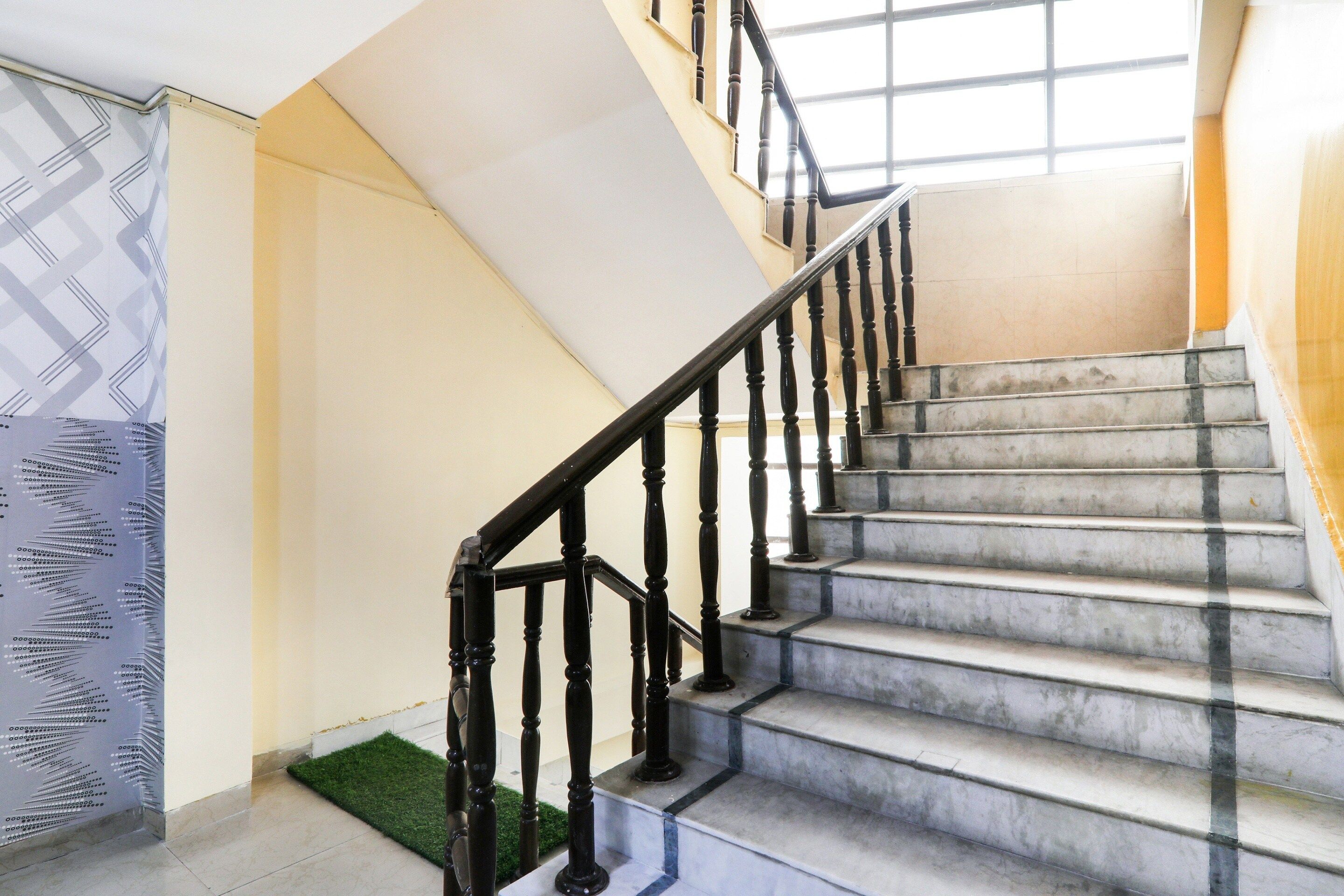 A staircase with a black handrail and marble steps.