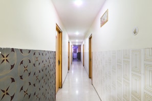 Un pasillo con paredes estampadas, puertas y piso de baldosas.
