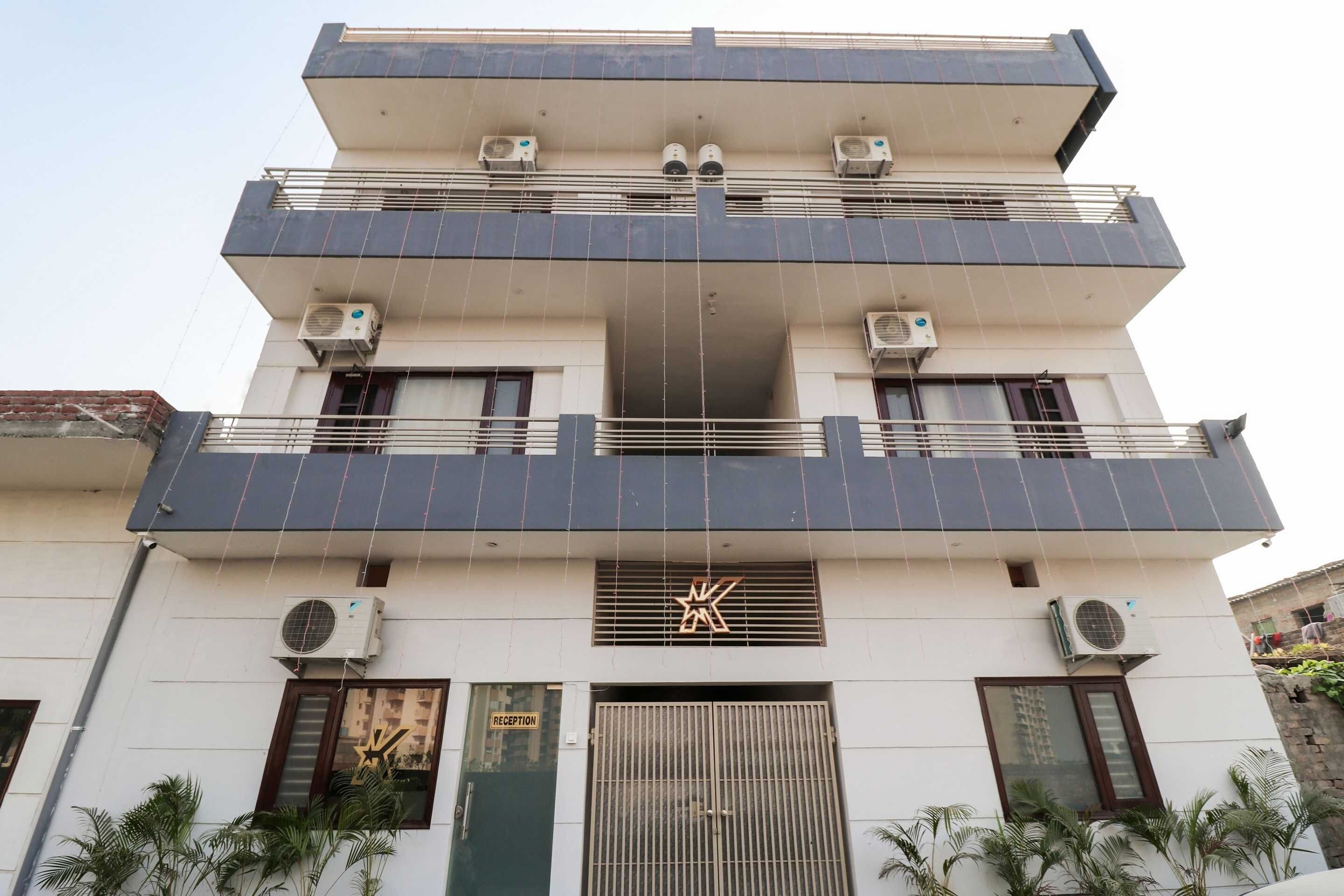 Un edificio de varios pisos con unidades de aire acondicionado, un cartel de recepción y una entrada con portón.