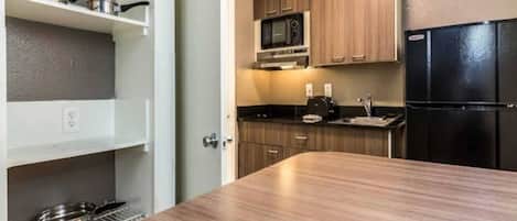 A compact kitchen with a microwave, stove, and refrigerator.