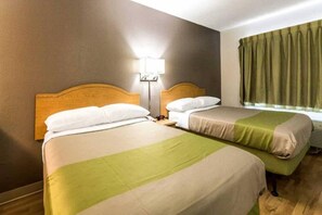 A hotel room with two beds, a nightstand, a lamp, and a window with curtains. - 2 Full Beds | Non-Smoking (Dallas)