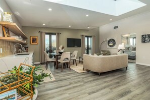 A modern living space with a dining area, a sofa, and a kitchen with a built-in sink. - Wine Country Retreat • Walk To Downtown + Tasting Rooms | The Agave Room (Paso Robles)