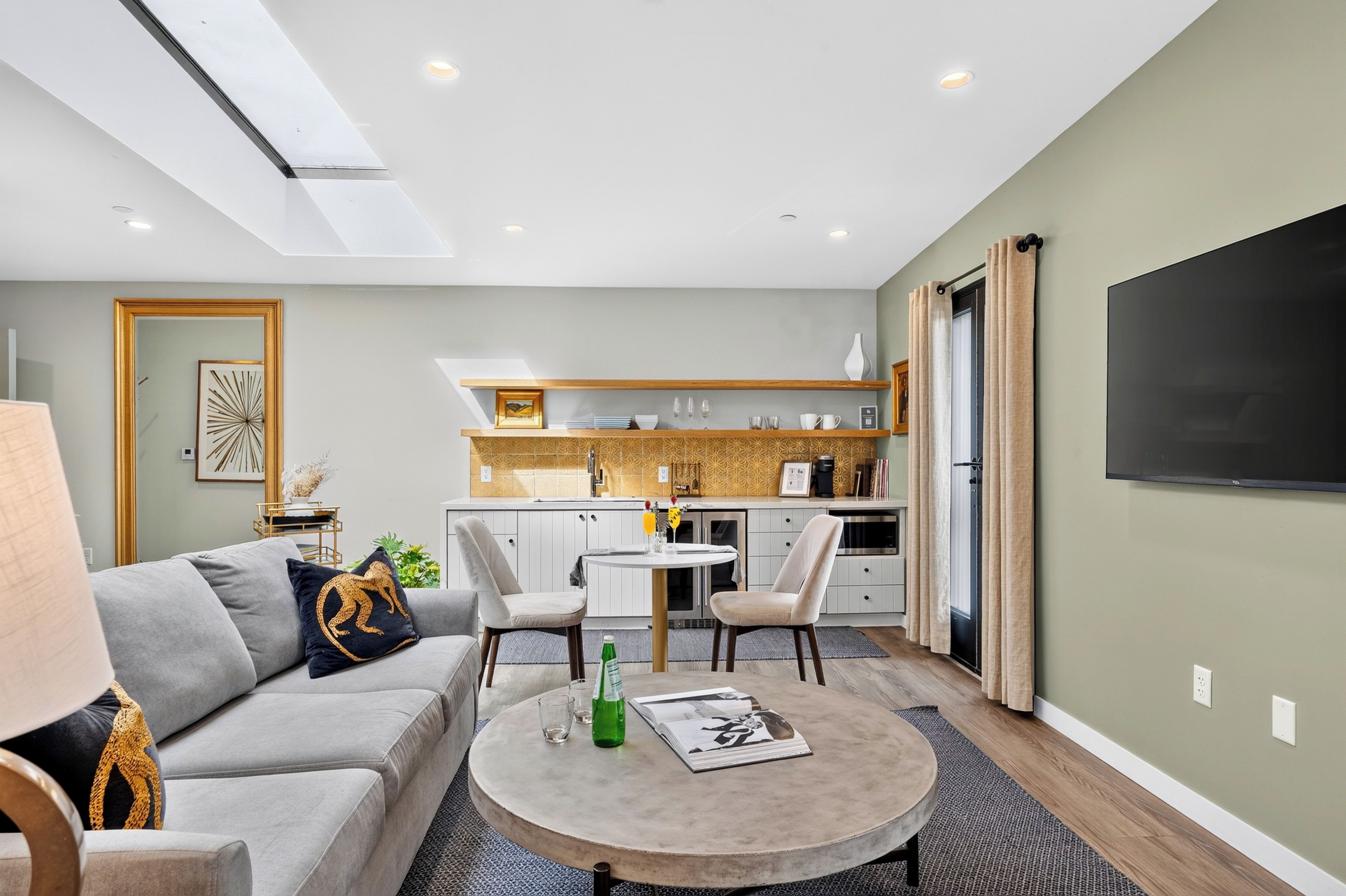 Settle into the bright living area, where a plush sofa, skylight, and connected kitchenette make relaxing between Paso adventures easy.