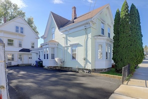 A residential street with houses, a clear sky, and a well-maintained lawn. - Lovely Merrimack Valley Home Near Local Eats (Lawrence)