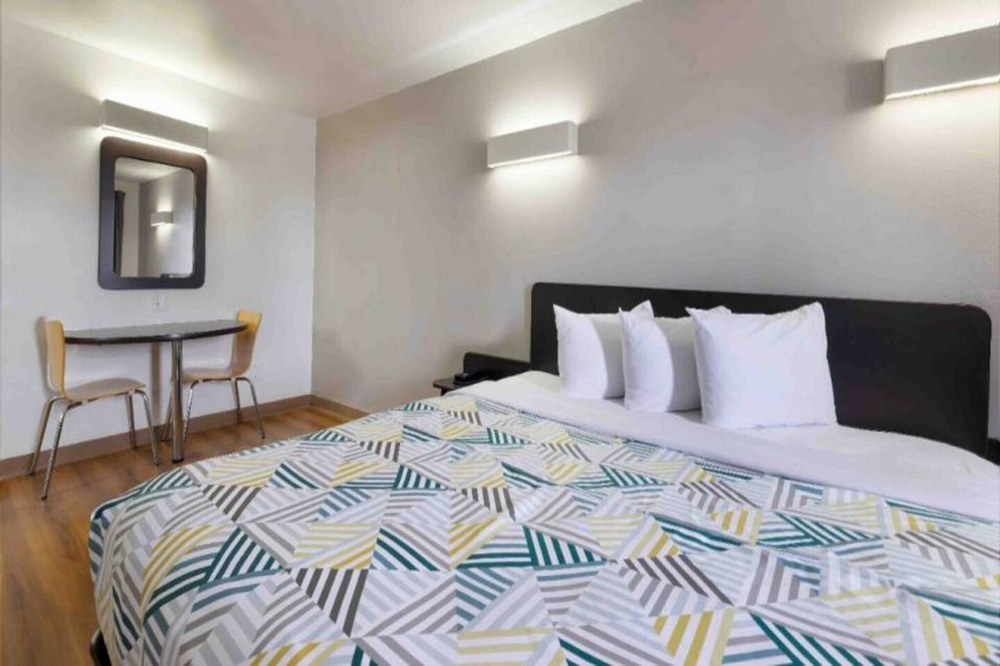 Una habitación de hotel con una cama, un escritorio y una silla.