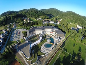 Vue aérienne d’un hôtel doté d’une piscine, de plusieurs bâtiments et d’un environnement verdoyant.