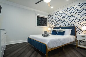 A bedroom with a bed, a window, a nightstand, and a dresser. - 8,000 sq ft Estate with Heated Pool & Game Room (Plantation)