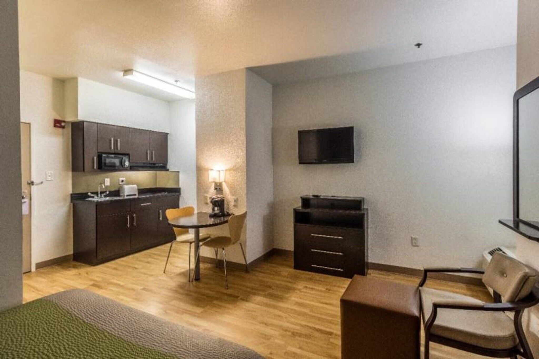 A compact living space with a kitchenette, a dining area, and a seating area.