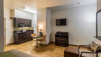 A compact living space with a kitchenette, a dining area, and a seating area.