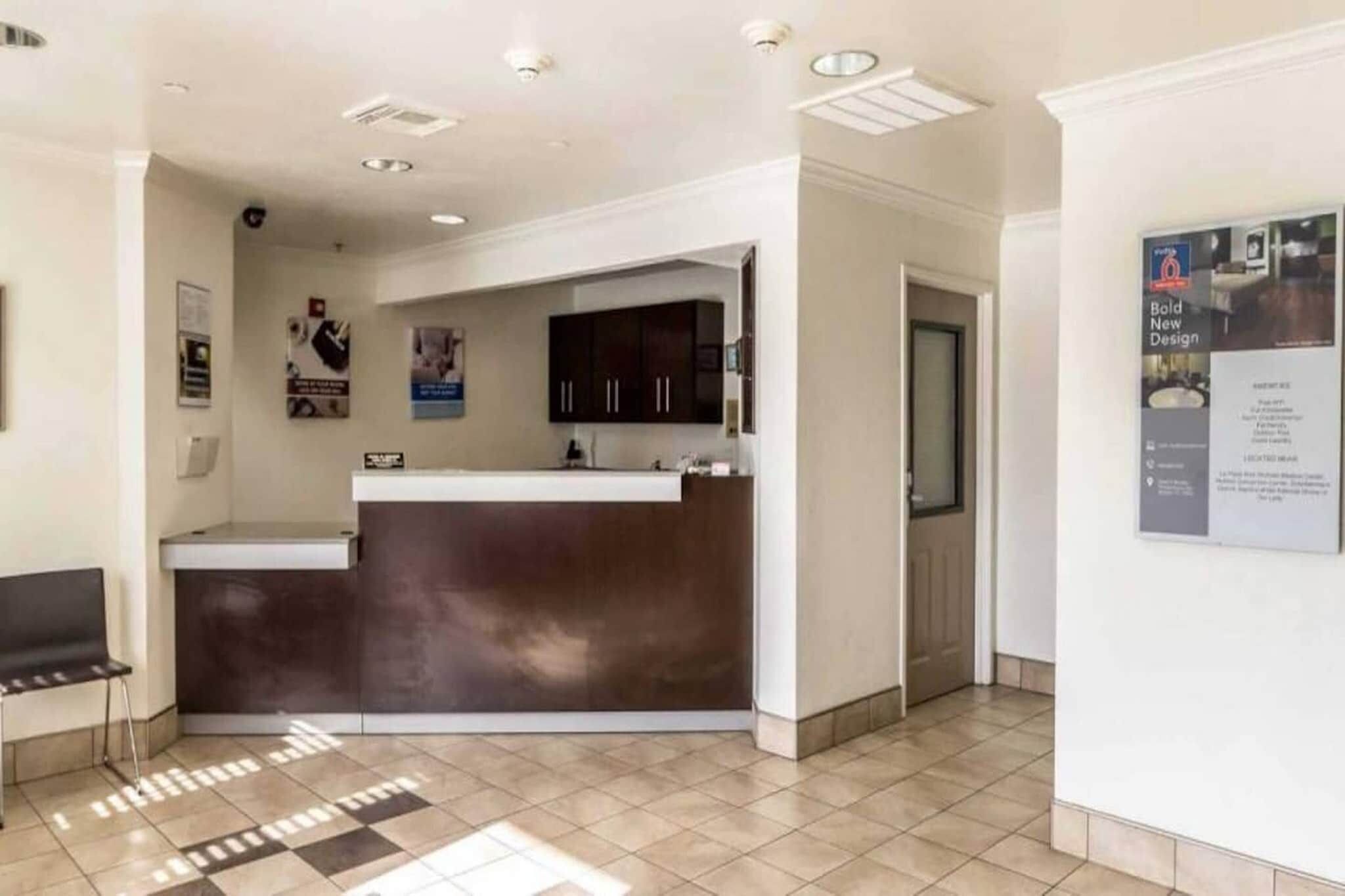 A reception area with a counter, a bench, and a door leading to another room.