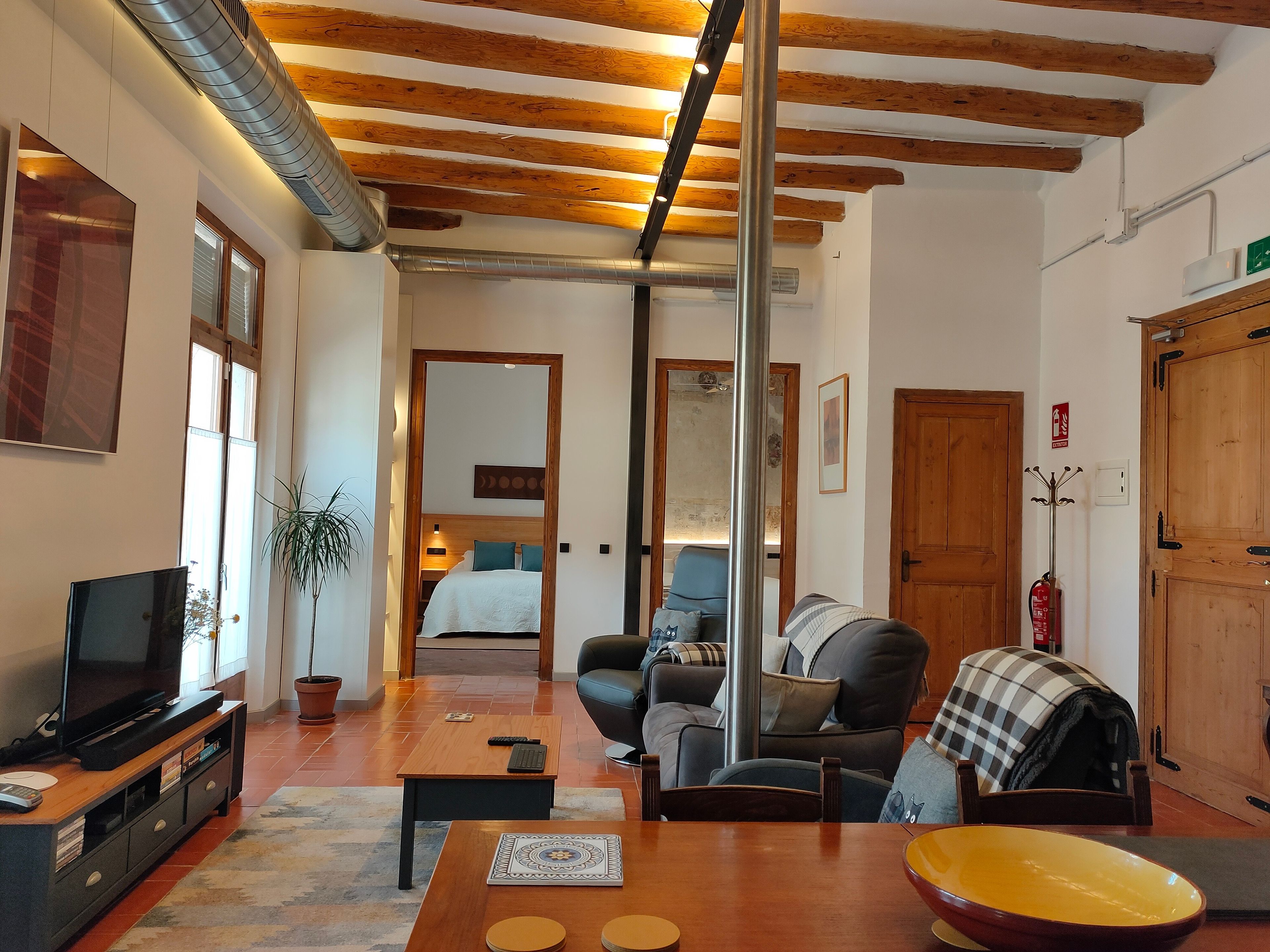 Un salon moderne avec un téléviseur, un canapé et une table basse.