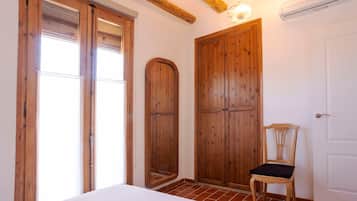 Ein Zimmer mit einem Bett, einem Holzschrank und einem Stuhl.