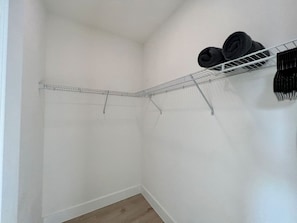 A small, empty room with a metal wire shelf against the wall and a wooden floor. - Pickleball/Gameroom/Soccer Field/Pool (Miami)