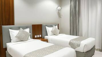 A hotel room with two beds, a modern headboard, a nightstand, and a large window with curtains.