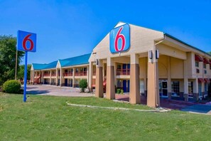 A motel with a large '6' sign, multiple-story structure, and a covered parking area. - 2 QUEEN BEDS | MOB ACC TUB NSMK MICFRIDG (ARLINGTON)