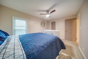 A bedroom with a bed, a ceiling fan, a dresser, and a door. - Walkable Main St Retreat! 5 Mi to Mount Pleasant (Cambridge Springs)
