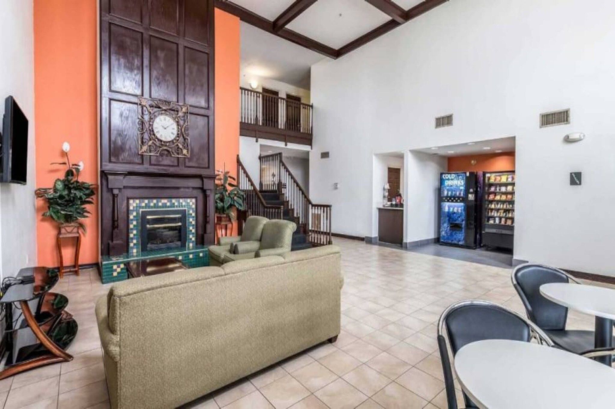 A spacious lobby with a fireplace, seating area, and a vending machine.