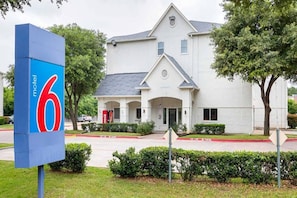 A motel with a large sign displaying the number 6. - Cozy 2 FULL BEDS | Nsmk (GRAND PRAIRIE)