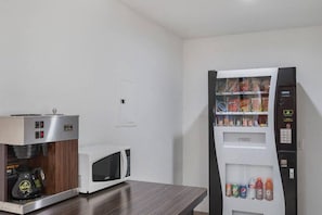 A kitchenette with a coffee machine, microwave, and a beverage dispenser. - Cozy 2 FULL BEDS | Nsmk (GRAND PRAIRIE)
