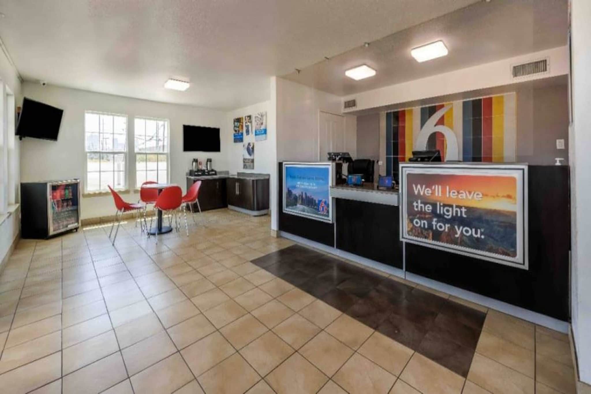 A reception area with a counter, chairs, and a large poster.