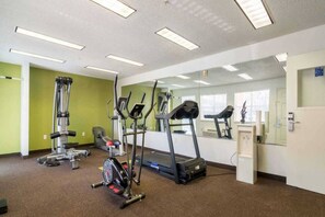 A gym with cardio machines, a treadmill, and a mirrored wall. - 1 King Bed | Smoking, Kitchen (Plano)
