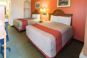 Ein Hotelzimmer mit zwei Betten, einem Schreibtisch und einem Stuhl.