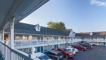 A motel with a covered parking area and multiple-story buildings.