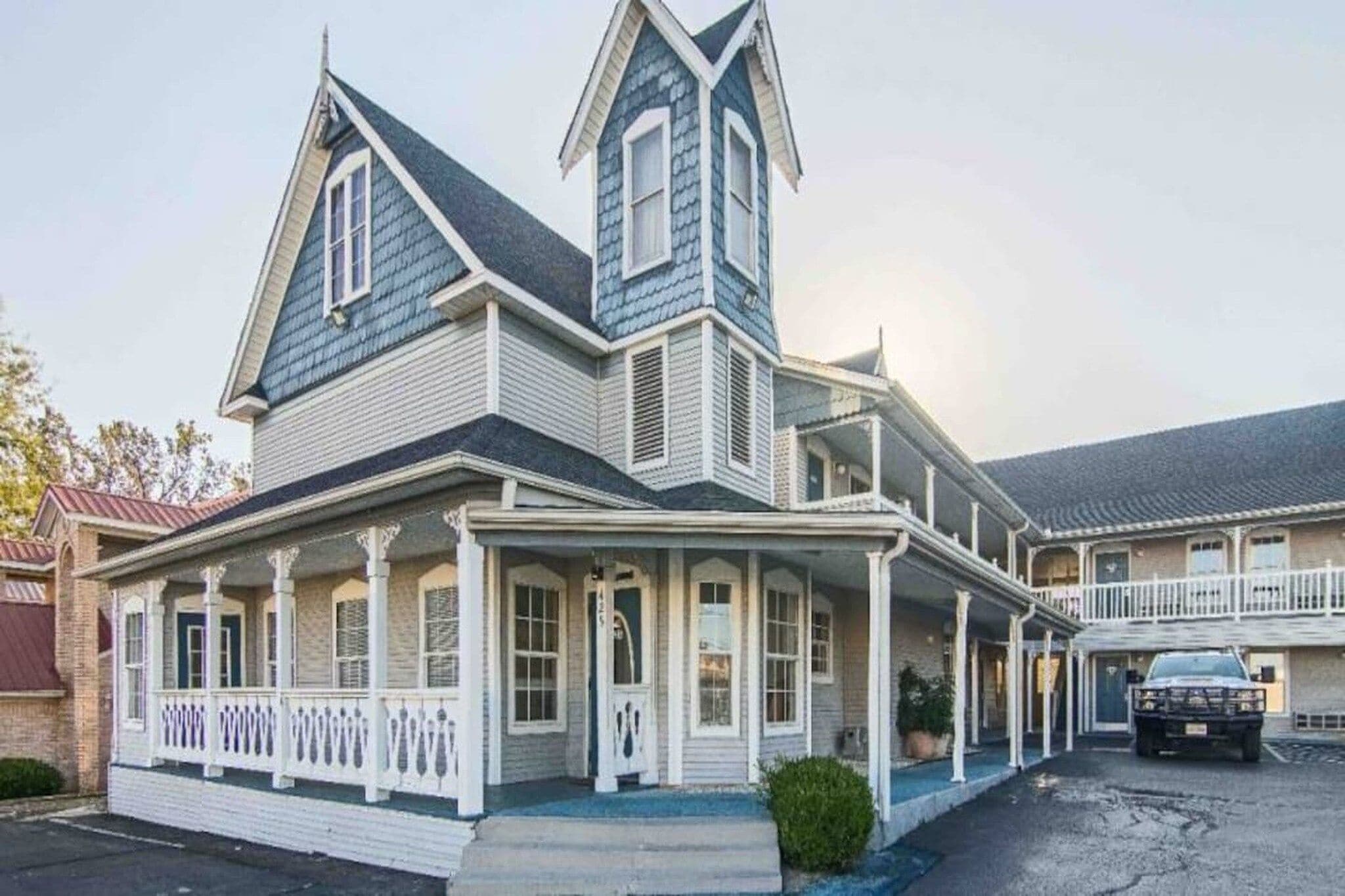 A large, two-story house with a prominent gable roof and a wrap-around porch.