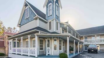 A large, two-story house with a prominent gable roof and a wrap-around porch.