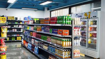 Un pasillo de supermercado con diversas bebidas y productos para el hogar.