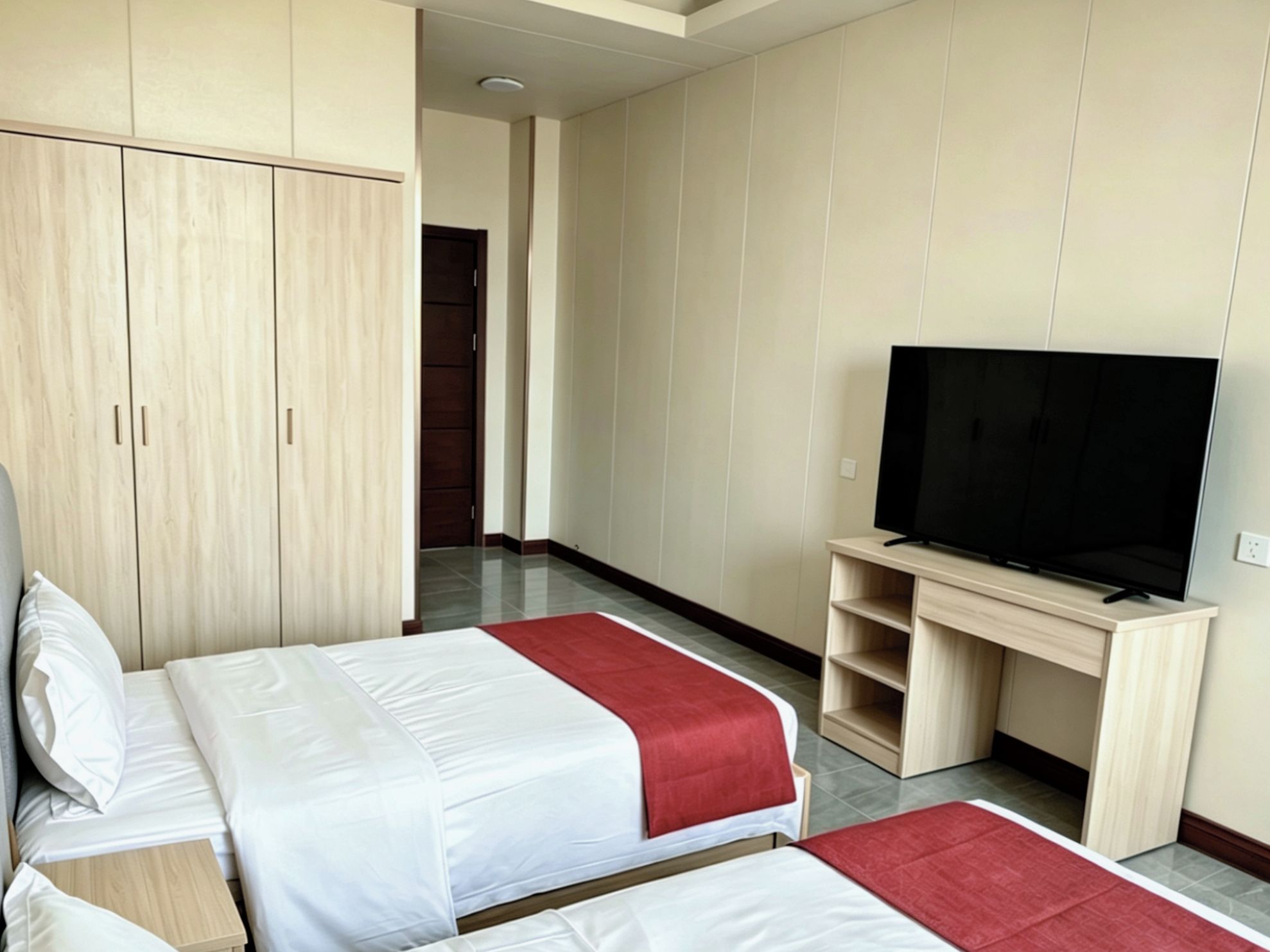Une chambre d’hôtel avec deux lits, une télévision et une armoire.