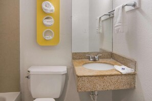 A bathroom with a toilet, sink, and mirror. - 2 full beds | smoking, micfridge (Fort Worth)