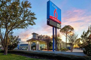 A hotel with a prominent sign indicating extended stay options and weekly specials. - 1 King Bed | Non-Smoking (DENTON)