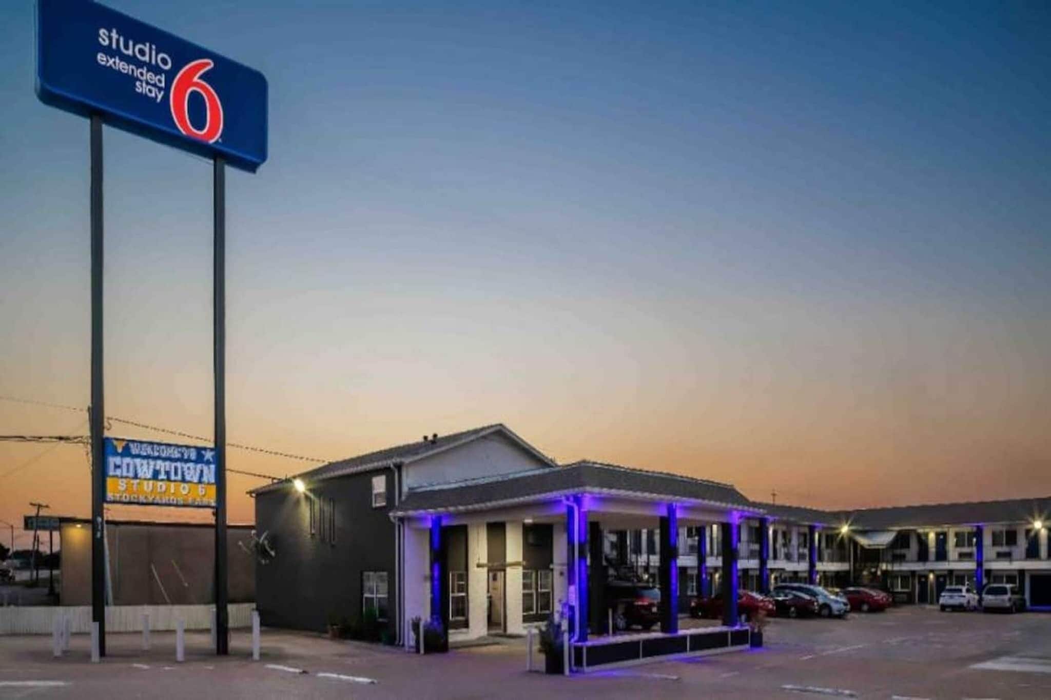 A motel with a sign for 'Studio Extended Stay 6' and a 'Welcome to Cowtown' sign.