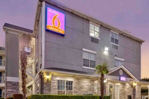 A multi-story hotel with a prominent 'studio 6 extended stay' sign. - 1 Queen Bed | Suite, Non-Smoking (Dallas)