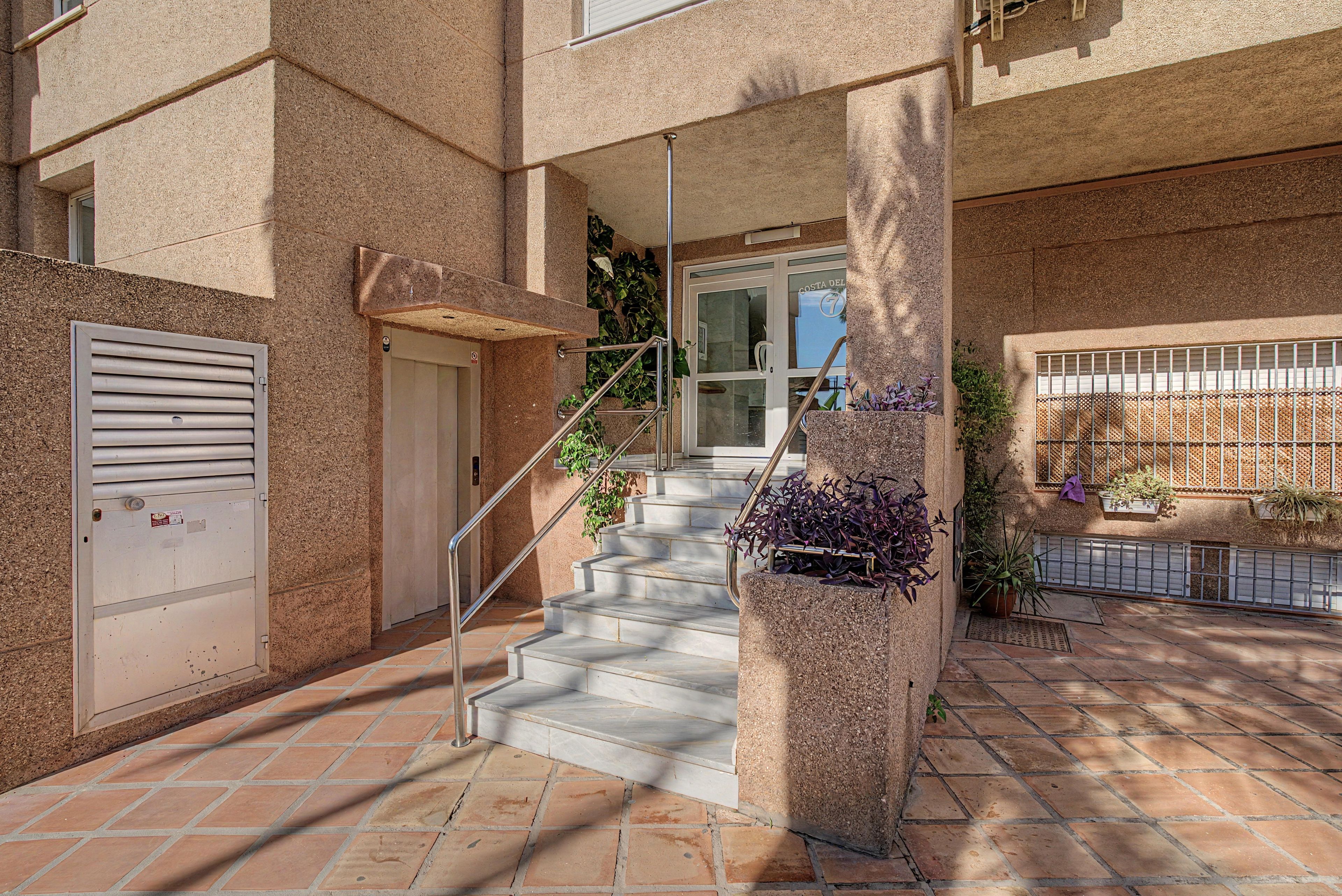 A building entrance with a staircase leading to a door marked 'COSTA DEL'.