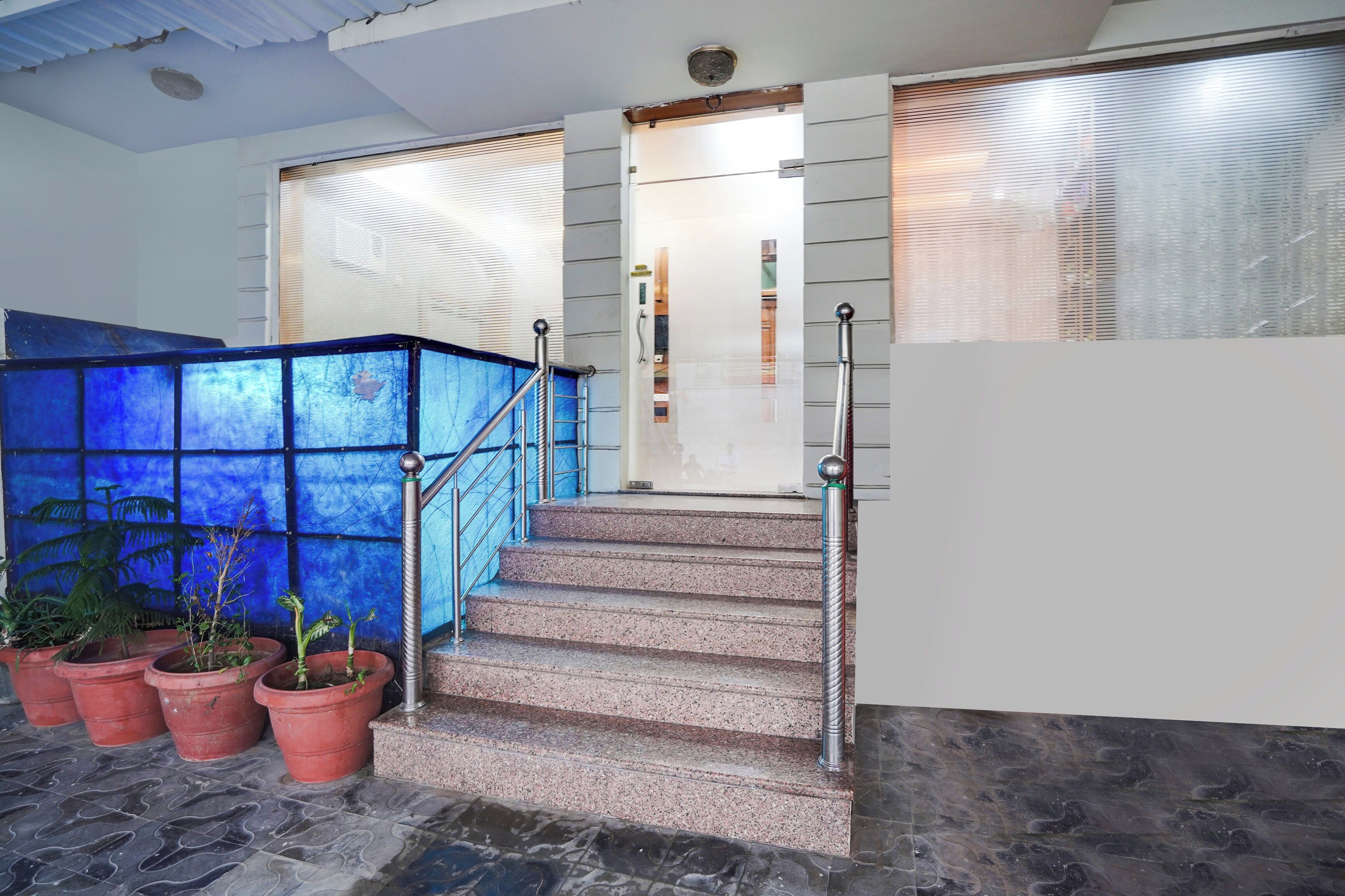 A staircase with metal railings leading to a door with a frosted glass panel.