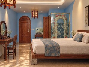 A bedroom with a bed, a dresser, a mirror, and a decorative wall. - Thiên Ý Lake Hotel (Phu Xuan)