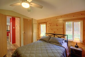 Ein Schlafzimmer mit einem Bett, einem Deckenventilator und einem Fenster.