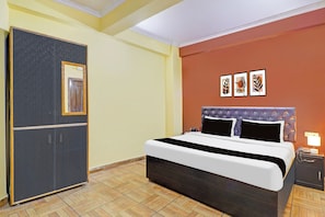 A hotel room with a bed, a wardrobe, and three framed pictures on the wall. - Hotel O Vidhan Sabha Chowk (Dehradun)