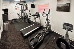 A home gym with a treadmill, elliptical, stationary bike, and weight machine. - 1 King Bed | Non-Smoking (Dallas)