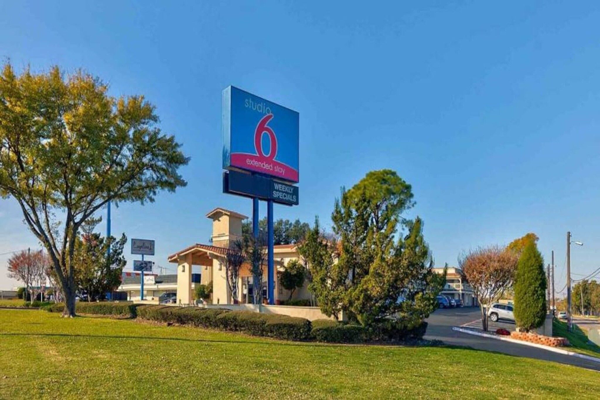 A hotel with a prominent sign advertising extended stay and weekly specials.
