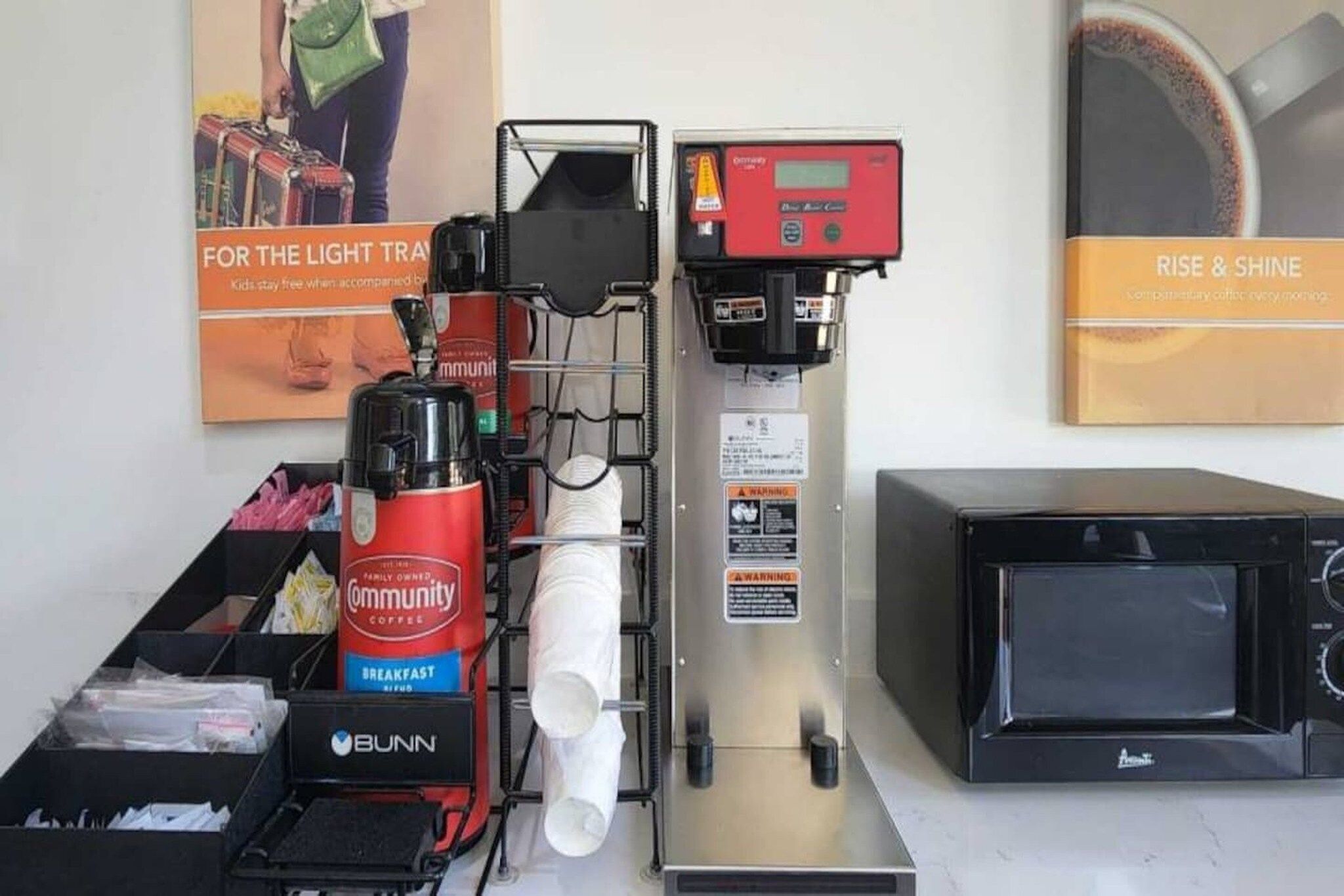 A coffee machine, a microwave, and a coffee grinder in a kitchen area.