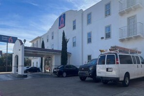 A building with a sign for 'motel+studio 6' and a white van parked in front. - 2 Queen Beds | Non-Smoking (Dallas)