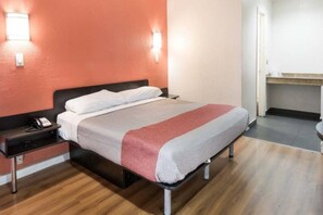 A hotel room with a bed, bedside table, and a telephone. - 1 King Bed | Non-Smoking, Micfridge (Fort Worth)