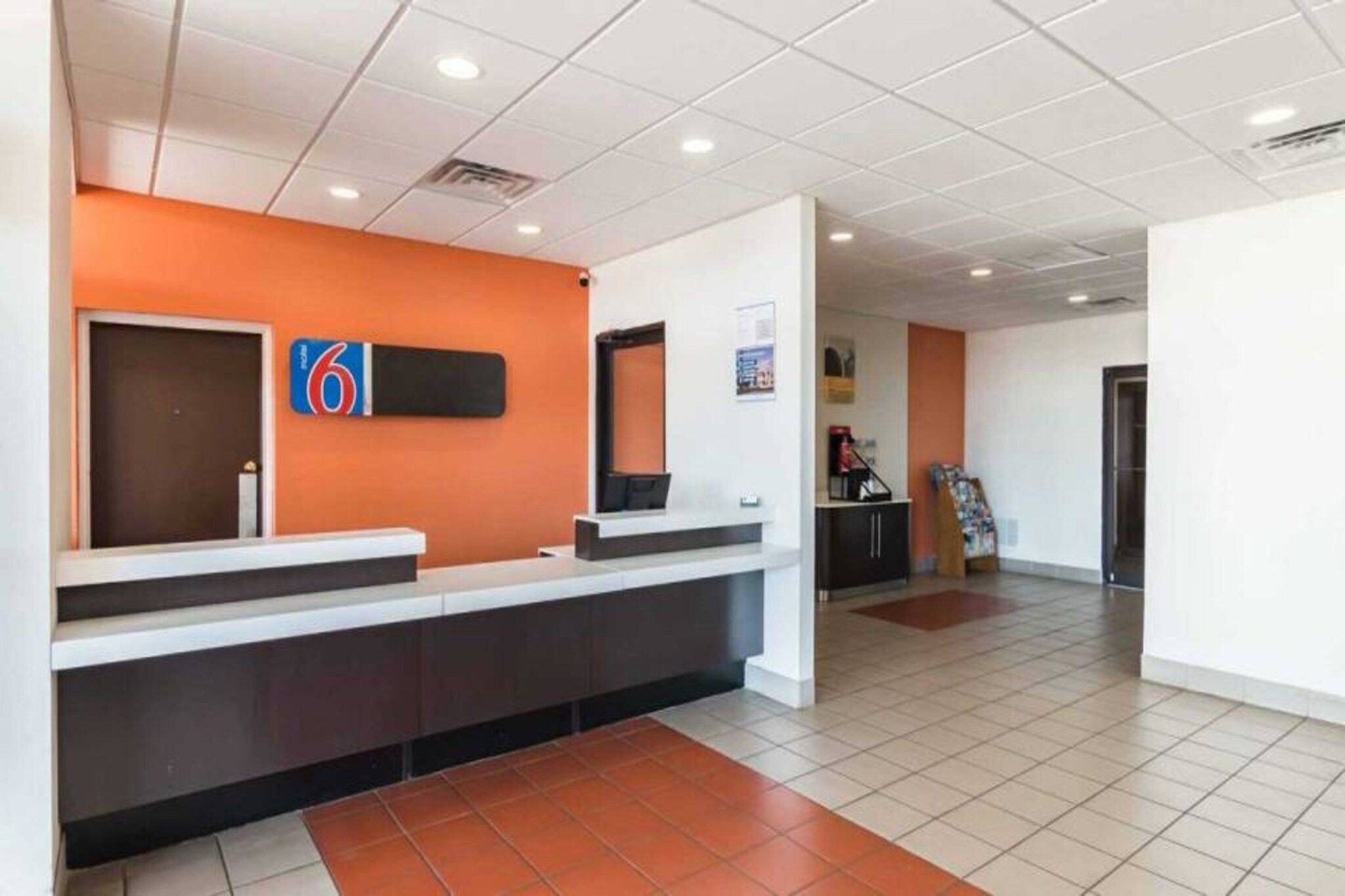 A reception area with a counter, a door, and a wall-mounted sign.