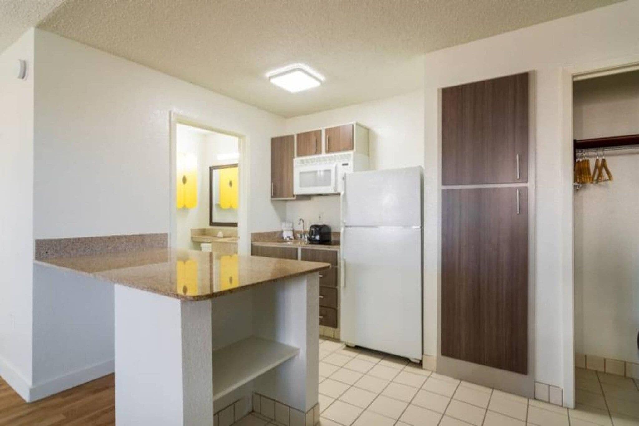 A compact kitchen with a microwave, refrigerator, and a small countertop.